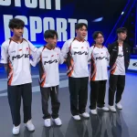 Sáu thành viên MVK Esports mặc áo trắng viền cam đứng trước nền xanh.