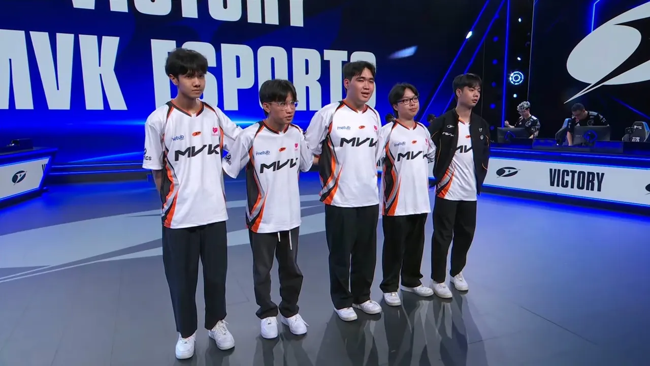 Sáu thành viên MVK Esports mặc áo trắng viền cam đứng trước nền xanh.