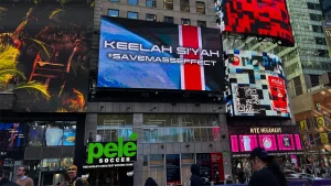 Biển quảng cáo có dòng Keelah Si’yah và SaveMassEffect phía trên cửa hàng Pelé giữa các màn hình tại Times Square.